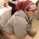 A girl with red-dyed hair and wearing glasses takes a runny-sounding shit while sitting on a toilet at home. She wipes her ass and looks at her dirty TP. About 4.5 minutes.